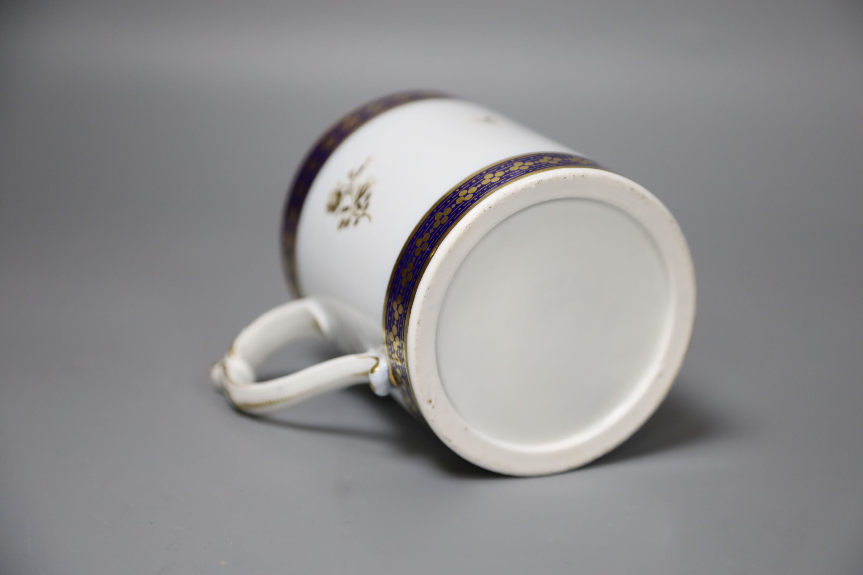 A 19th century Barr Worcester fine mug with a distinctive handle painted in under glaze blue and gilded with floral sprays, height 11cm